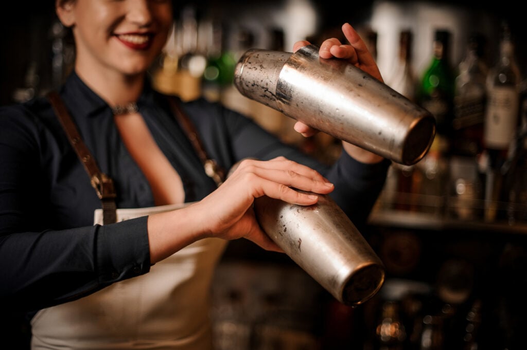 Bartender making a fresh summer cocktail in shaker